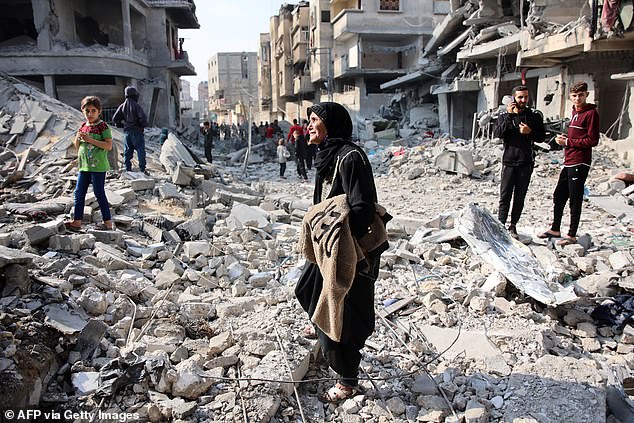 Palestinians walk amid the destruction following an Israeli strike in Jabalia in the northern Gaza Strip on November 10, 2024