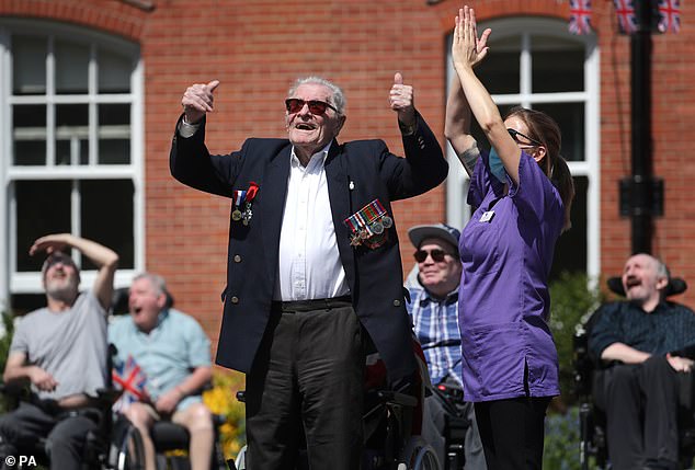 Second World War veteran Len Gibbon, 96, stands to watch a Spitfire fly over the Care for Veterans site in Worthing, Sussex, to mark the 75th anniversary of VE Day in 2020