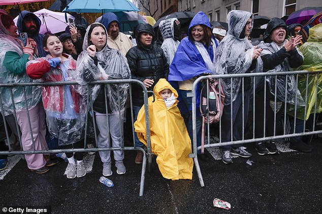 People line up to watch the parade decked out in rain gear