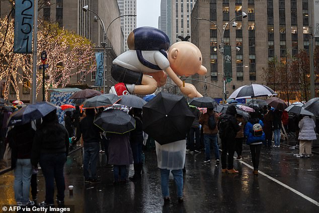 Crowds watch the Diary of a Wimpy Kid balloon float go by