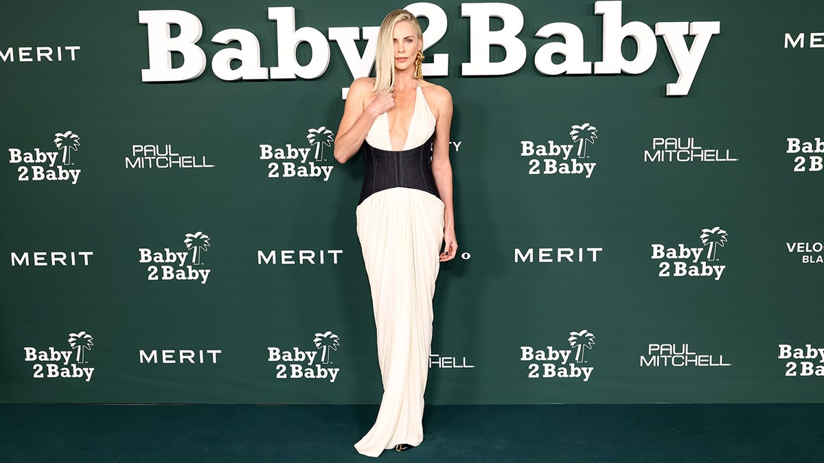 Charlize Theron wore a white silk Schiaparelli gown with a plunging neckline and black corset.