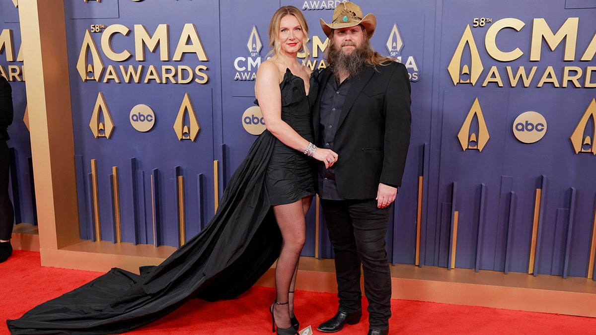 Chris Stapleton and his wife Morgane walked the red carpet at the 2024 CMA Awards in a black dress and black suit respectively.