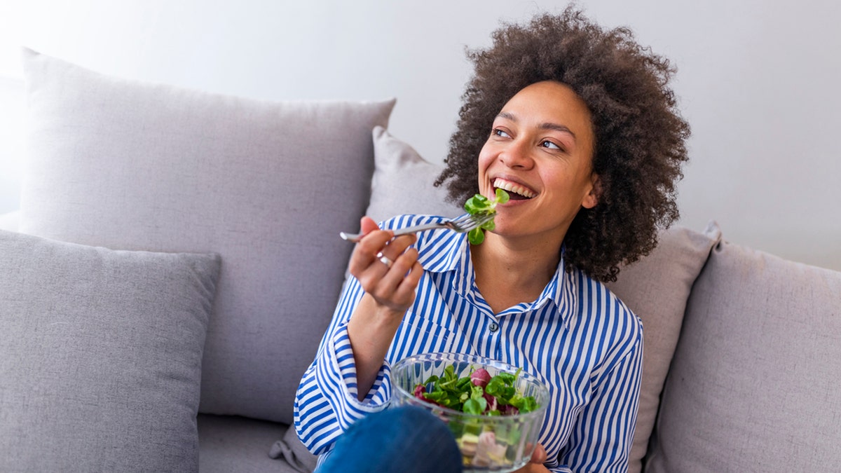 woman on the sofa eating a healthy salad