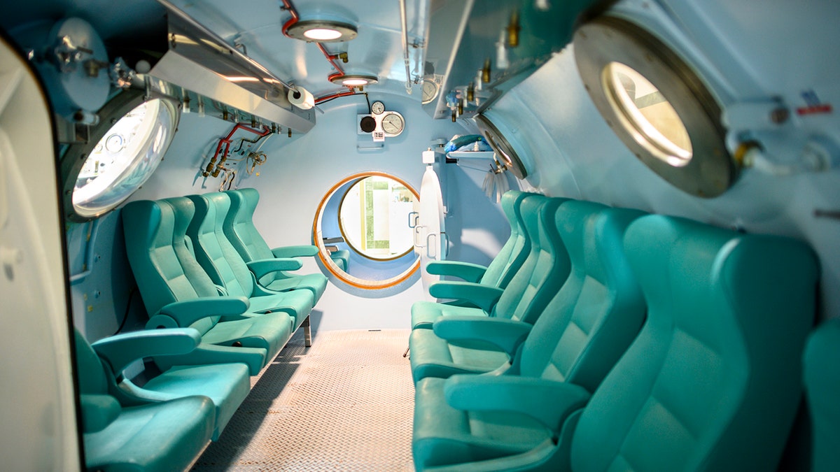 An interior of a large hyperbaric chamber with rows of seats.