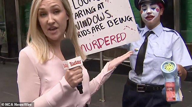 One protester had clown makeup on and was dressed in a fake police uniform holding the sign  'you look stupid staring at windows when kids are being murdered'