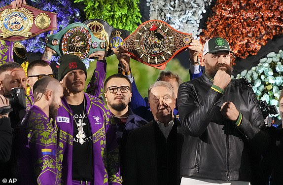 Boxers Britain's Tyson Fury, right, and world champion Ukraine's Oleksandr Usyk, center left, stand on stage during the weigh-in for their WBA, WBO, and WBC heavyweight title bout in Riyadh, Saudi Arabia, Friday, Dec. 20, 2024. (AP Photo/Frank Augstein)