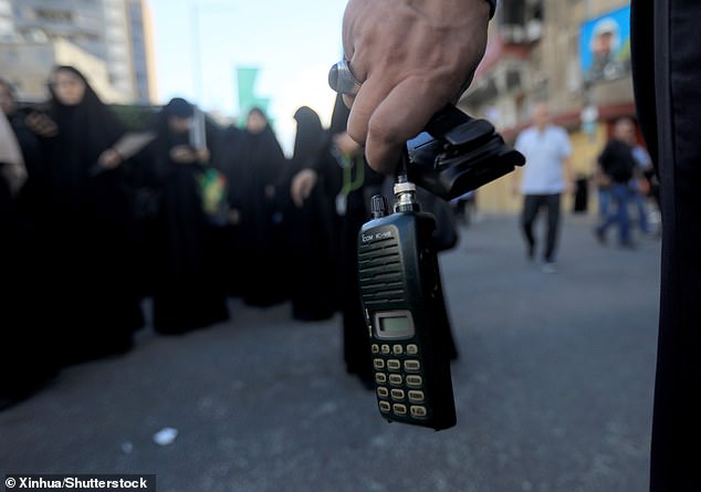 Photo taken on Sept. 18, 2024 shows a wireless communication device in the hand of a Hezbollah member, the battery of which was removed after a wireless communication device exploded during a funeral, in Beirut, Lebanon