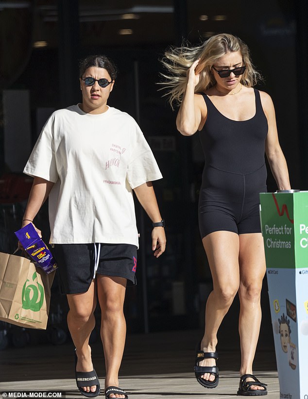 The Chelsea striker shielded her eyes with blue reflective shades and carried a shopping bag in one hand as they picked up some Christmas essentials, including a box of chocolates