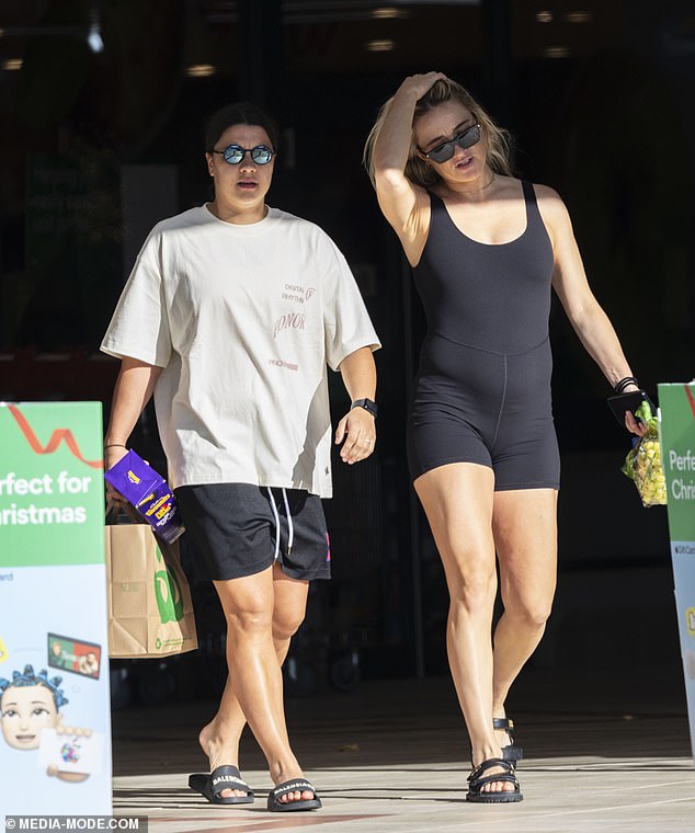 Sam was seen avidly chatting away to her partner Kristie, who showed off her blossoming baby bump in a figure-hugging black unitard