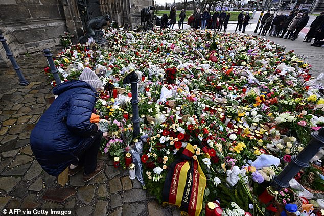 Tributes to the victims of the devastating attack are seen near the market on December 22