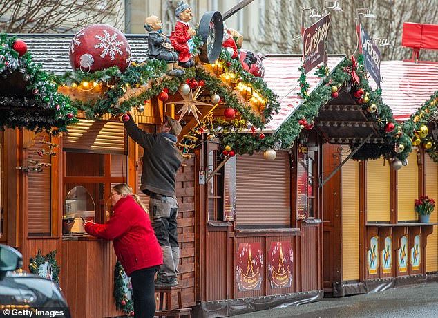 Stall holders at the now closed Christmas market clean their shop front on December 23, 2024