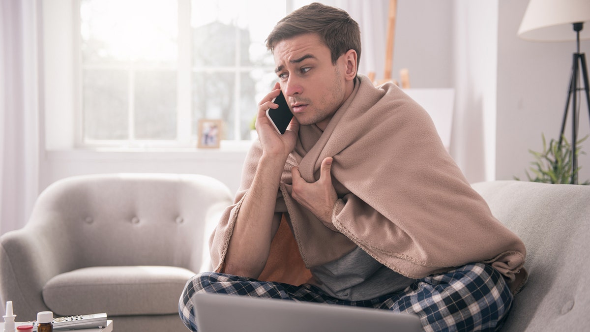 man talking on the phone to his employer asking about sick leave