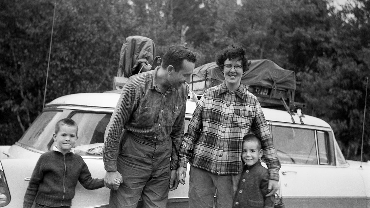 Car packed and ready to go in background for family vacation in 1957