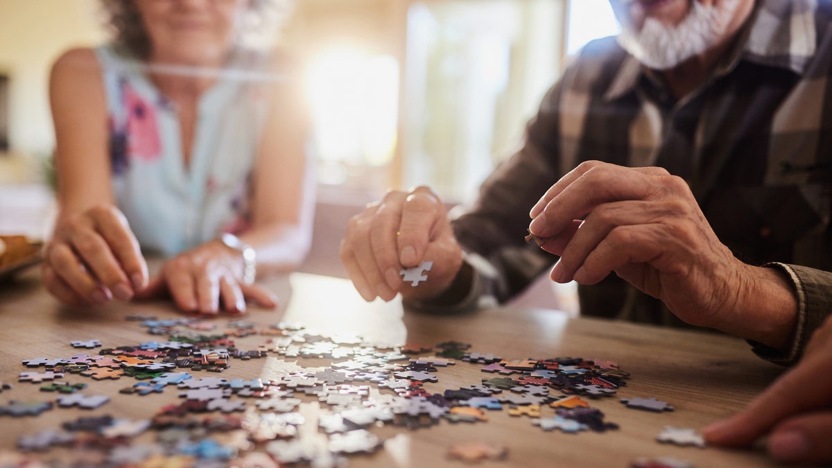 Close up of senior couple playing jigsaw puzzles