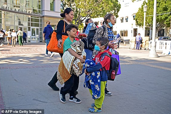 People arrive at an evacuation center in the Pasadena Convention Center in Pasadena, California, as they flee wildfires in the Los Angeles area on January 10, 2025. Massive wildfires that engulfed whole neighborhoods and displaced thousands in Los Angeles have killed at least 10 people, authorities said, as California's National Guard soldiers readied to hit the streets to help quell disorder. News of the growing toll, announced late Thursday January 9 by the Los Angeles County Medical Examiner, came as swaths of the United States' second-largest city lay in ruins. (Photo by Agustin PAULLIER / AFP) (Photo by AGUSTIN PAULLIER/AFP via Getty Images)