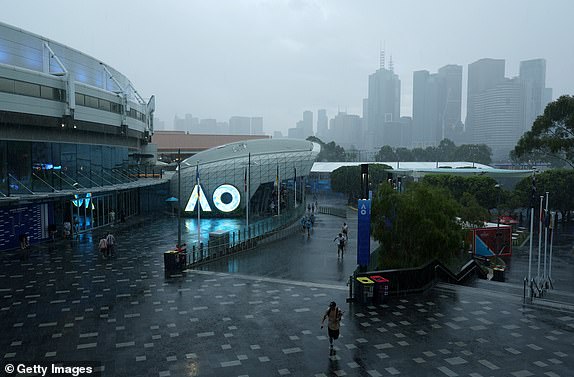 MELBOURNE, AUSTRALIA - JANUARY 12: Fans walk in the rain during day one of the 2025 Australian Open at Melbourne Park on January 12, 2025 in Melbourne, Australia. (Photo by Graham Denholm/Getty Images)