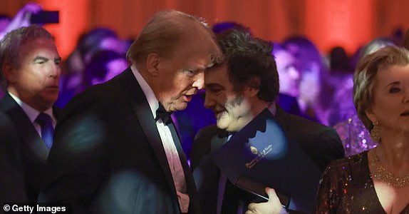 PALM BEACH, FLORIDA - NOVEMBER 14: Argentine President Javier Milei walks past U.S. President-elect Donald Trump as they attend the America First Policy Institute Gala held at Mar-a-Lago on November 14, 2024 in Palm Beach, Florida. The annual event supports Grey Team, a nonprofit organization dedicated to preventing military suicide. (Photo by Joe Raedle/Getty Images)