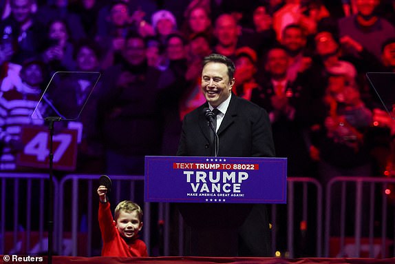 Tesla CEO and X owner Elon Musk reacts next to his son during a rally for U.S. President-elect Donald Trump the day before Trump is scheduled to be inaugurated for a second term, in Washington, U.S., January 19, 2025. REUTERS/Evelyn Hockstein