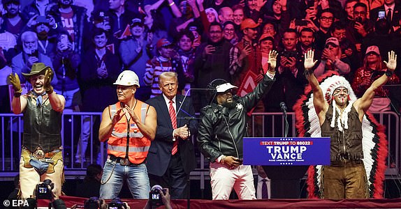 epa11837538 US President-elect Donald Trump (C) with the group the Village People at a rally at Capital One Arena in Washington, DC, USA, 19 January 2025. President-elect Donald Trump, who defeated Joe Biden to become the 47th president of the United States, will be inaugurated on 20 January, though all of the planned outdoor ceremonies and events have been cancelled due to a forecast of extreme cold temperatures.  EPA/WILL OLIVER