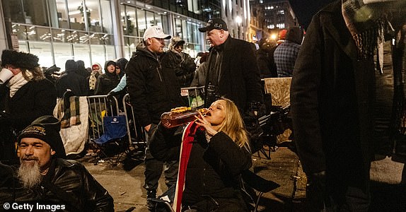 WASHINGTON, DC - JANUARY 20: Zan Luna, a former marine from Colorado, takes a swig of whiskey as she waits on line to get into Capital One Arena for Donald Trump's inauguration celebration on January 20, 2025 in Washington, DC. U.S. President-elect Donald Trump and Vice President-elect JD Vance will be sworn in on January 20 in an indoor ceremony in the rotunda of the U.S. Capitol with a celebration at the Arena after. (Photo by Stephanie Keith/Getty Images)