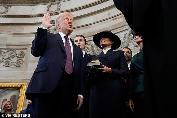 Donald Trump is sworn in as the 47th president of the United States by Chief Justice John Roberts as Melania Trump holds the Bible during the 60th Presidential Inauguration in the Rotunda of the U.S. Capitol in Washington, Monday, Jan. 20, 2025.     Morry Gash/Pool via REUTERS