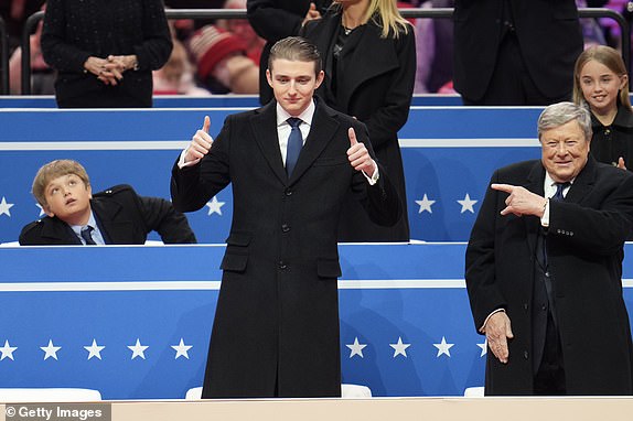 WASHINGTON, DC - JANUARY 20: Baron Trump (L) and Viktor Knavs attend an indoor inauguration parade at Capital One Arena on January 20, 2025 in Washington, DC. Donald Trump takes office for his second term as the 47th president of the United States. (Photo by Christopher Furlong/Getty Images)