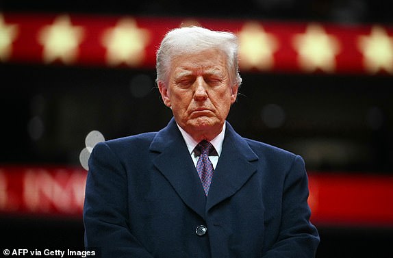 US President Donald Trump closes his eyes as he observes a moment of silence for firefighter Corey Comperatore who was killed during the assassination attempt on Donald Trump, during the inaugural parade inside Capital One Arena, in Washington, DC, on January 20, 2025. (Photo by Jim WATSON / AFP) (Photo by JIM WATSON/AFP via Getty Images)