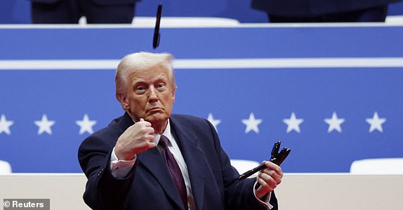 U.S. President Donald Trump throws a pen during a rally on the inauguration day of his second Presidential term, inside Capital One, in Washington, U.S. January 20, 2025. REUTERS/Mike Segar