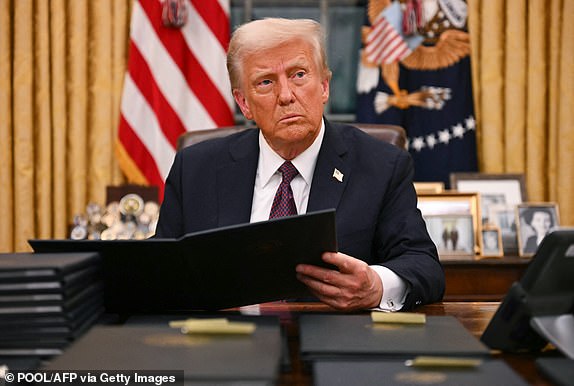 US President Donald Trump signs an executive order for pardons on January 6 offenders in the Oval Office of the WHite House in Washington, DC, on January 20, 2025. (Photo by Jim WATSON / POOL / AFP) (Photo by JIM WATSON/POOL/AFP via Getty Images)