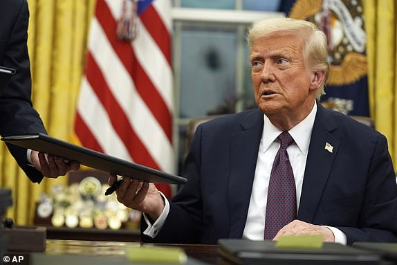 President Donald Trump signs executive orders in the Oval Office of the White House, Monday, Jan. 20, 2025, in Washington. (AP Photo/Evan Vucci)