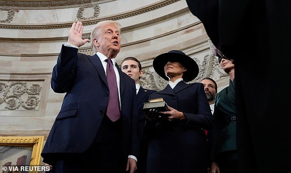 Donald Trump is sworn in as the 47th president of the United States by Chief Justice John Roberts as Melania Trump holds the Bible during the 60th Presidential Inauguration in the Rotunda of the U.S. Capitol in Washington, Monday, Jan. 20, 2025.     Morry Gash/Pool via REUTERS