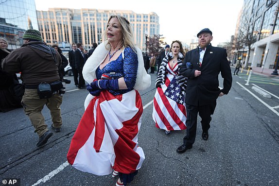 People wearing ball gowns walk the streets of Washington following the 60th Presidential Inauguration, Monday, Jan. 20, 2025. (AP Photo/Mike Stewart)