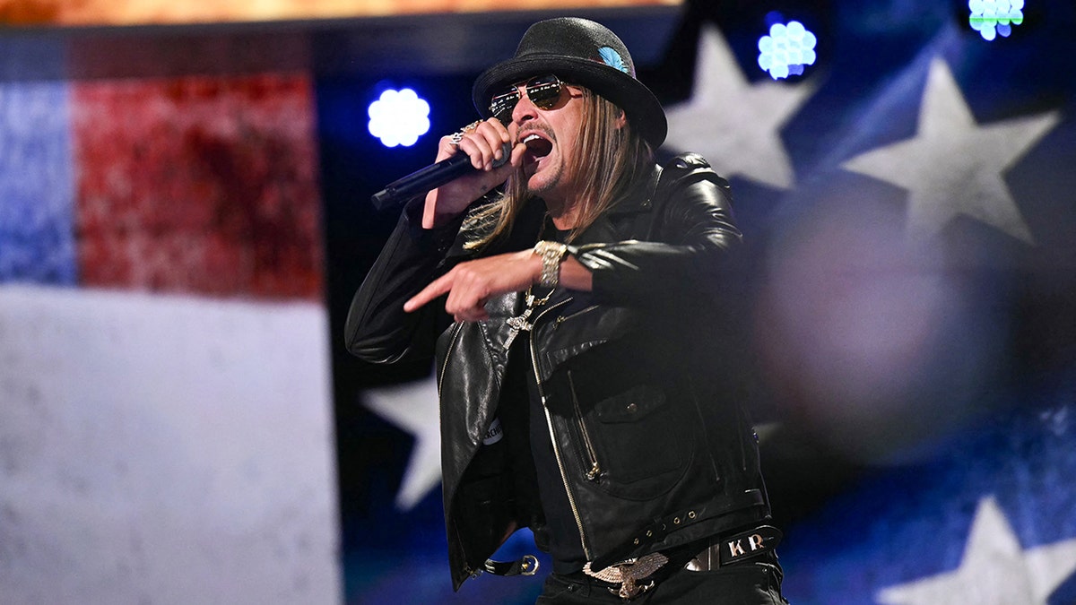 Kid Rock in a black leather jacket and hat sing passionately on stage at the RNC