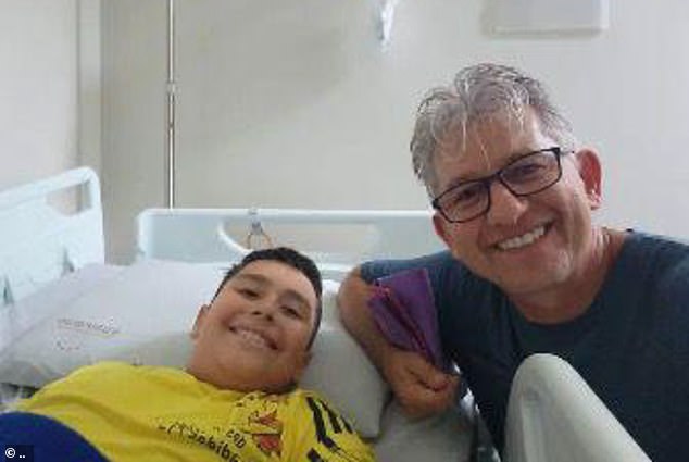 10 year old Matheus Marques da Silva who survived eating the poisoned cake with Father Leonir Alves at the hospital in Torres, Brazil