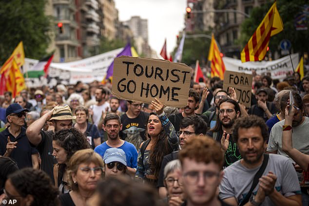 Demonstrators march shouting slogans against the Formula 1 Barcelona Fan Festival in downtown Barcelona, Spain, Wednesday, June 19, 2024