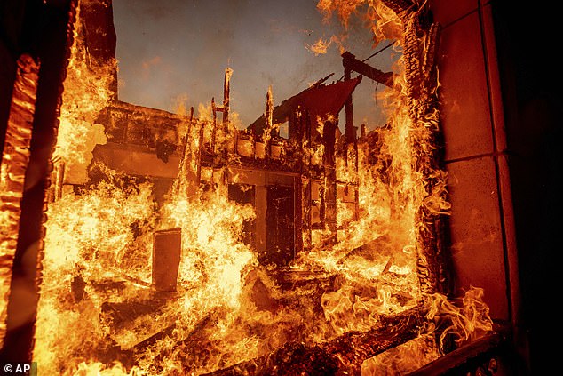 The Palisades Fire burns a residence in the Pacific Palisades area of Los Angeles yesterday