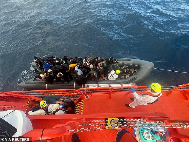 Spanish coast guards wearing white suits work on a rescue operation as they tow a rubber boat carrying migrants, including a newborn baby, off the island off the Canary Island of Lanzarote, in Spain, in this handout picture obtained on January 8, 2025