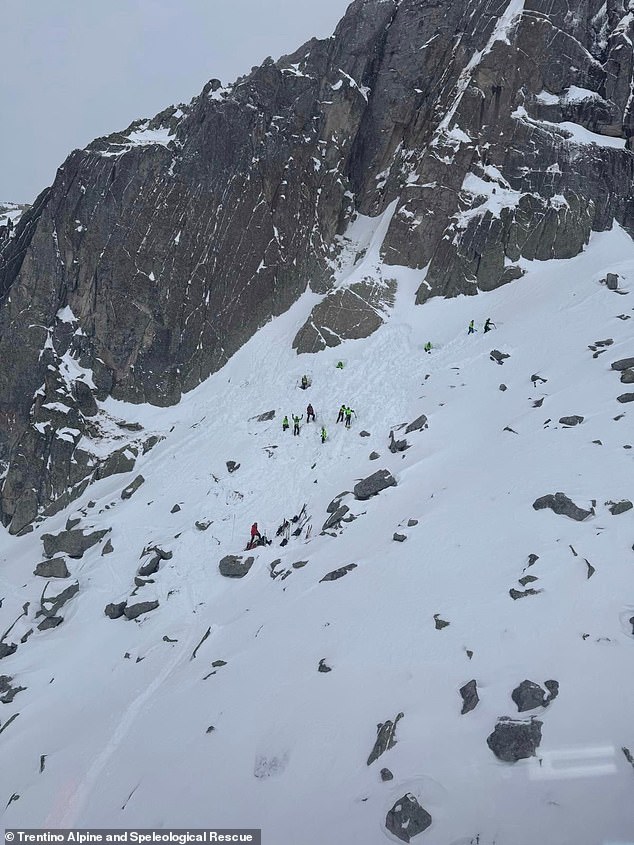 Rescuers are pictured on a mountain after the body of Sam Harris was located in the Dolomites