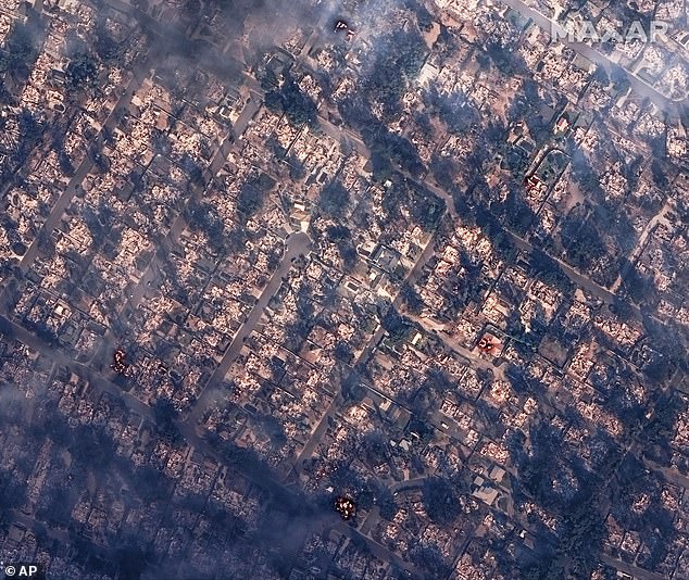 This satellite image provided by Maxar Technologies shows burning and destroyed houses