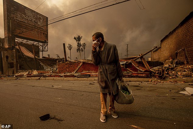 A man walks past a fire-ravaged business after the Eaton Fire