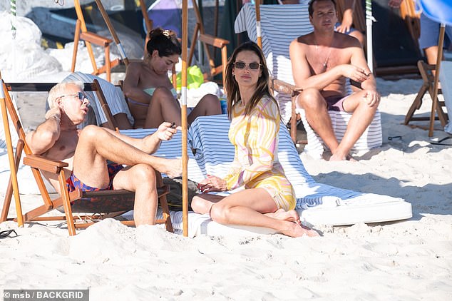 Alessandra pictured sitting with friends