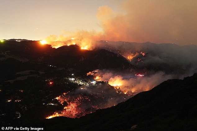 Flames and smoke from the Palisades Fire surround a home  in the community of Topanga