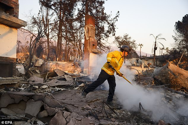 Firefighters hose down the burning remains of a structure in Altadena, California