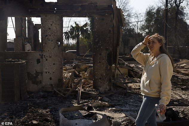 Victoria Bower looks at the remains of her home in Altadena, California. Multiple wildfires continue to burn across thousands of acres in Southern California