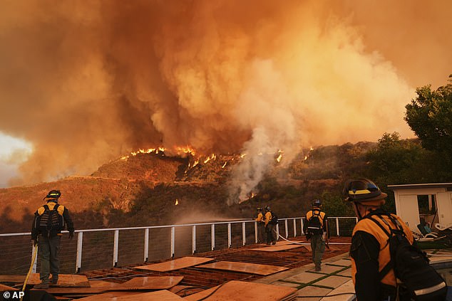 Fire crews monitor and tackle the Palisades Fire in Mandeville Canyon on Saturday