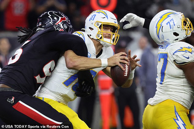 Justin Herbert (10) is sacked by Denico Autry (96) during the third quarter on Saturday