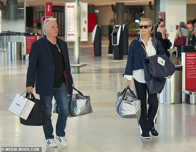 He finished off his look with a pair of white Adidas sneakers as he also carried handfuls of baggage through the airport