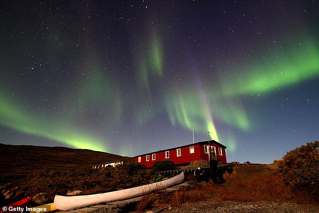 The Aurora Borealis glows over a hut near the town of Kangerlussuaq September 02, 2007, in the Greenland town of Kangerlussuaq