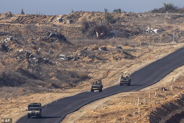 Israeli military vehicles move inside the Gaza Strip, as seen from southern Israel, on January 7