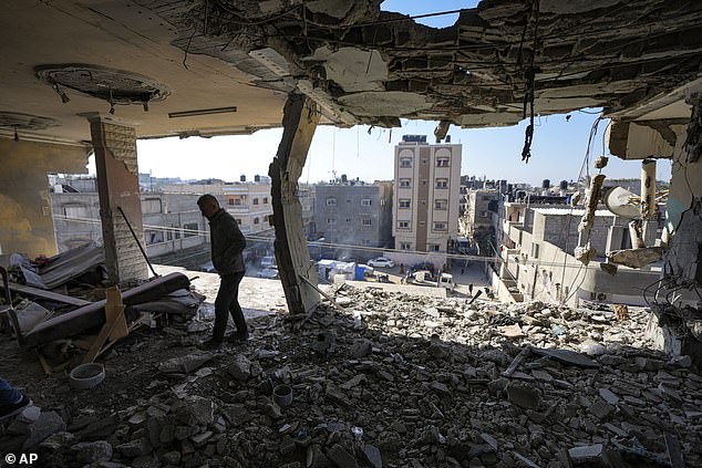 A Palestinian looks at a damaged residential building following an overnight Israeli strike in Deir al-Balah on January 8